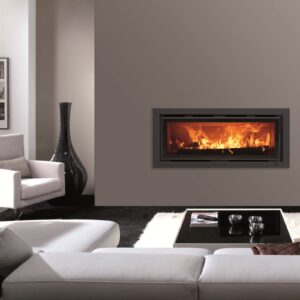 Inserto de chimenea a leña Panadero 101 S encendido, empotrado en la pared de un living